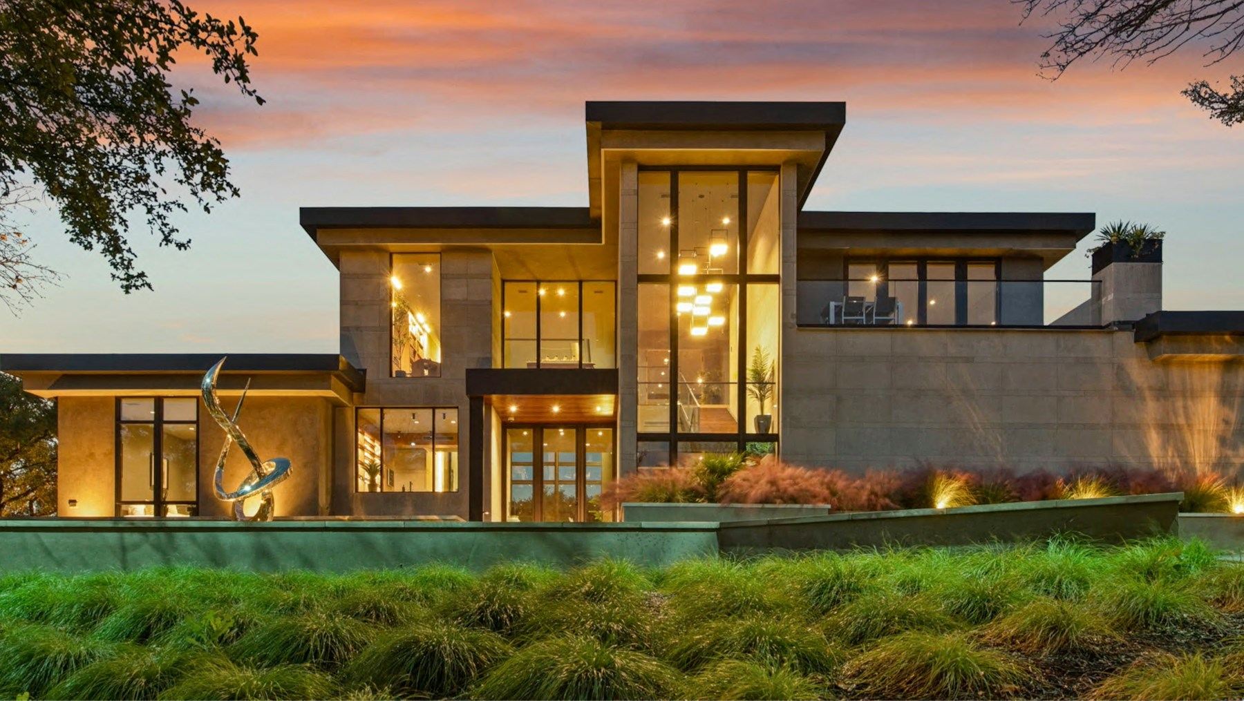 Luxury modern home with large glass windows at dusk